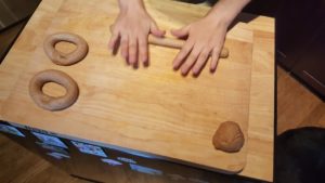 Take a ball of dough and roll it out evenly from the middle to make a rope. Pinch the two ends together. Let rest for another hour. Preheat oven to 200C (390°F)